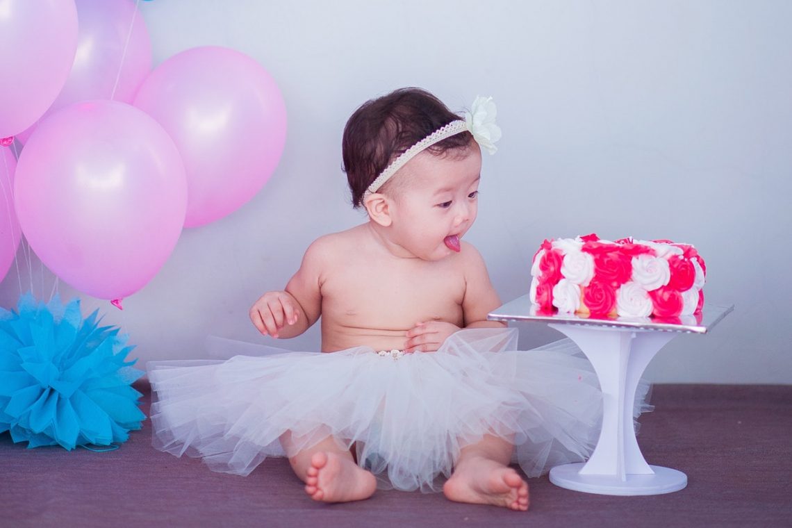 kind in rokje tijdens kinderfeestje op tafel op verjaardagstaart te eten